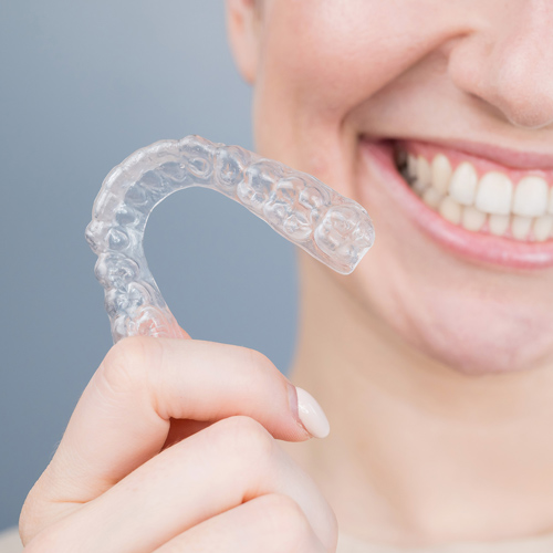 Girl holding Invisalign tray at Geelong orthodontist.